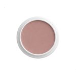 Round white compact containing dusty pink blush, viewed from above (top-down cosmetic photo)