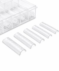 Six clear 1.5 mL microcentrifuge tubes with graduated marks laid in a row near a transparent rack.