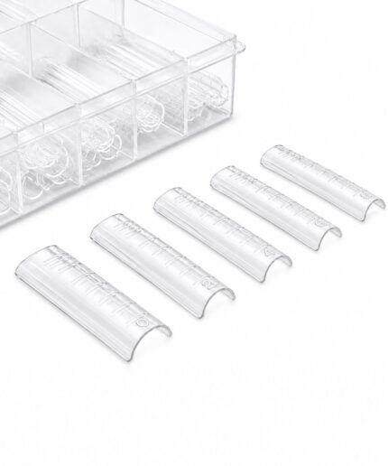 Six clear 1.5 mL microcentrifuge tubes with graduated marks laid in a row near a transparent rack.