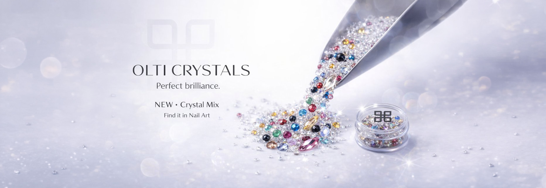 Colorful crystals pouring from a metal tool into a small jar on a pale, sparkling background (OLTI CRYSTALS branding).