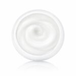 Top-down view of a clear jar filled with smooth white cream, swirl pattern visible in the center