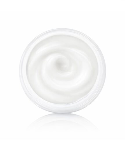 Top-down view of a clear jar filled with smooth white cream, swirl pattern visible in the center