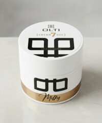 White cylindrical cosmetic jar labeled OLTI Cream Gel — Self Leveling Milky, with bold black geometric logo and a gold band at the base.